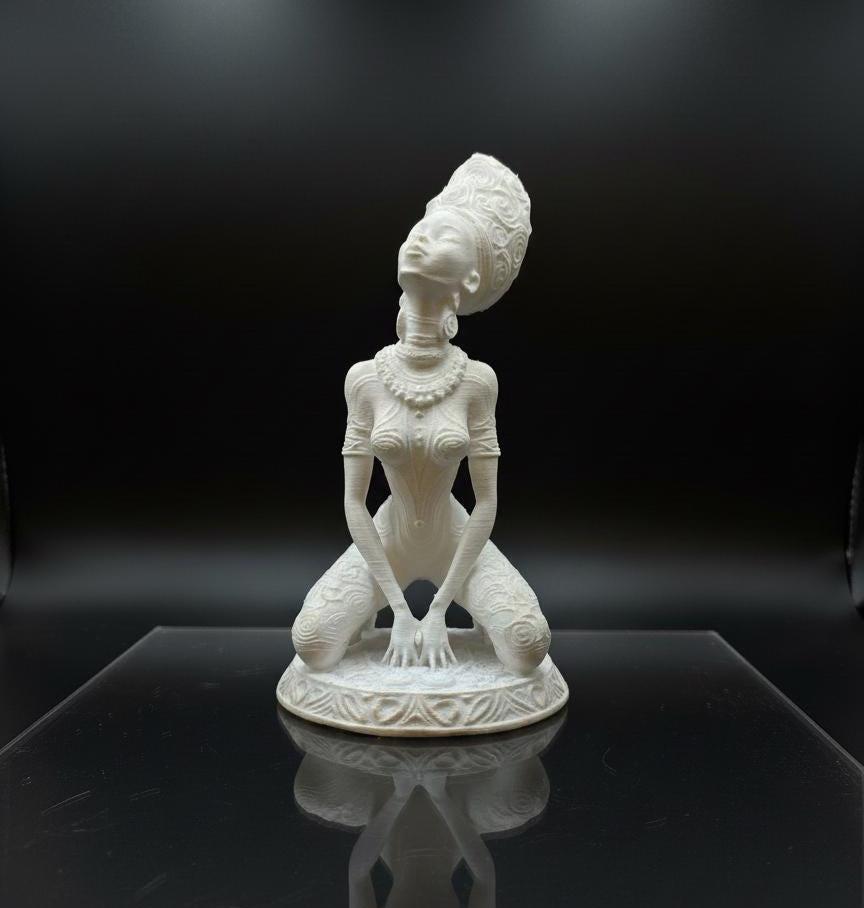 A unique, studio-exclusive Afrofuturist goddess statue in white with hand-applied gold mica highlights.